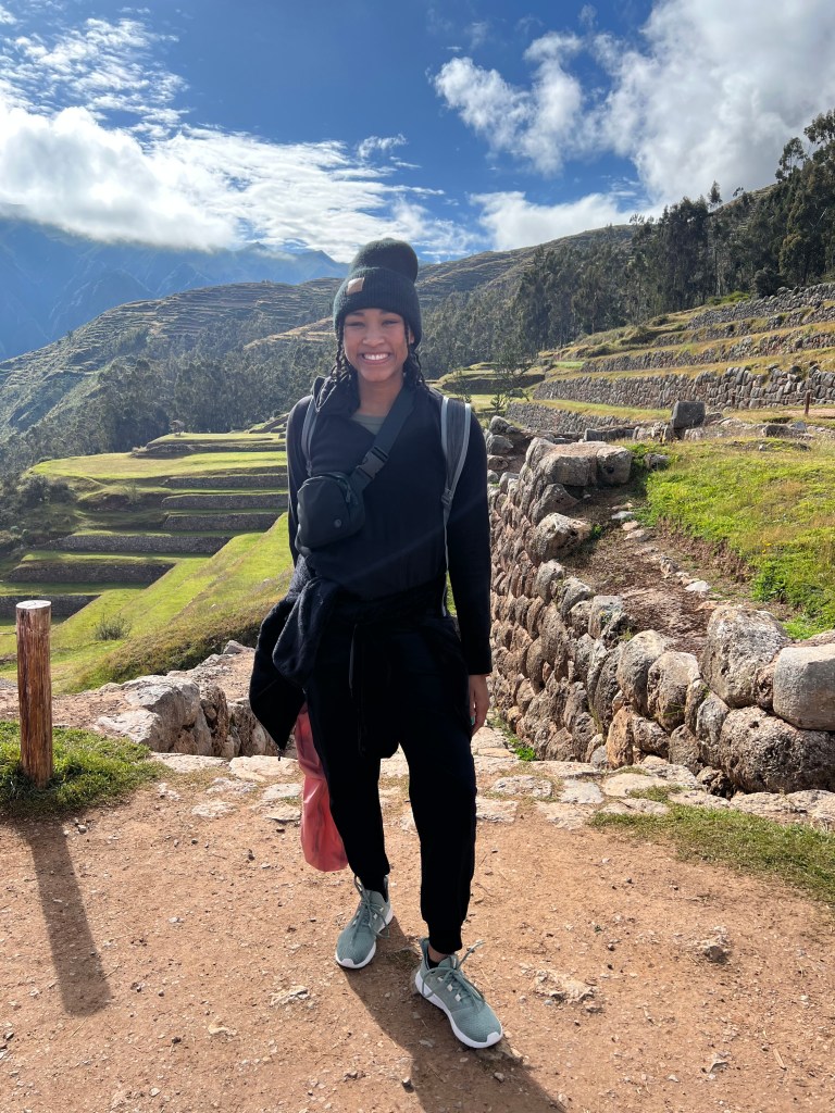Blair is wearing athletic wear while hiking in a beautiful place on a sunny day with blue skies